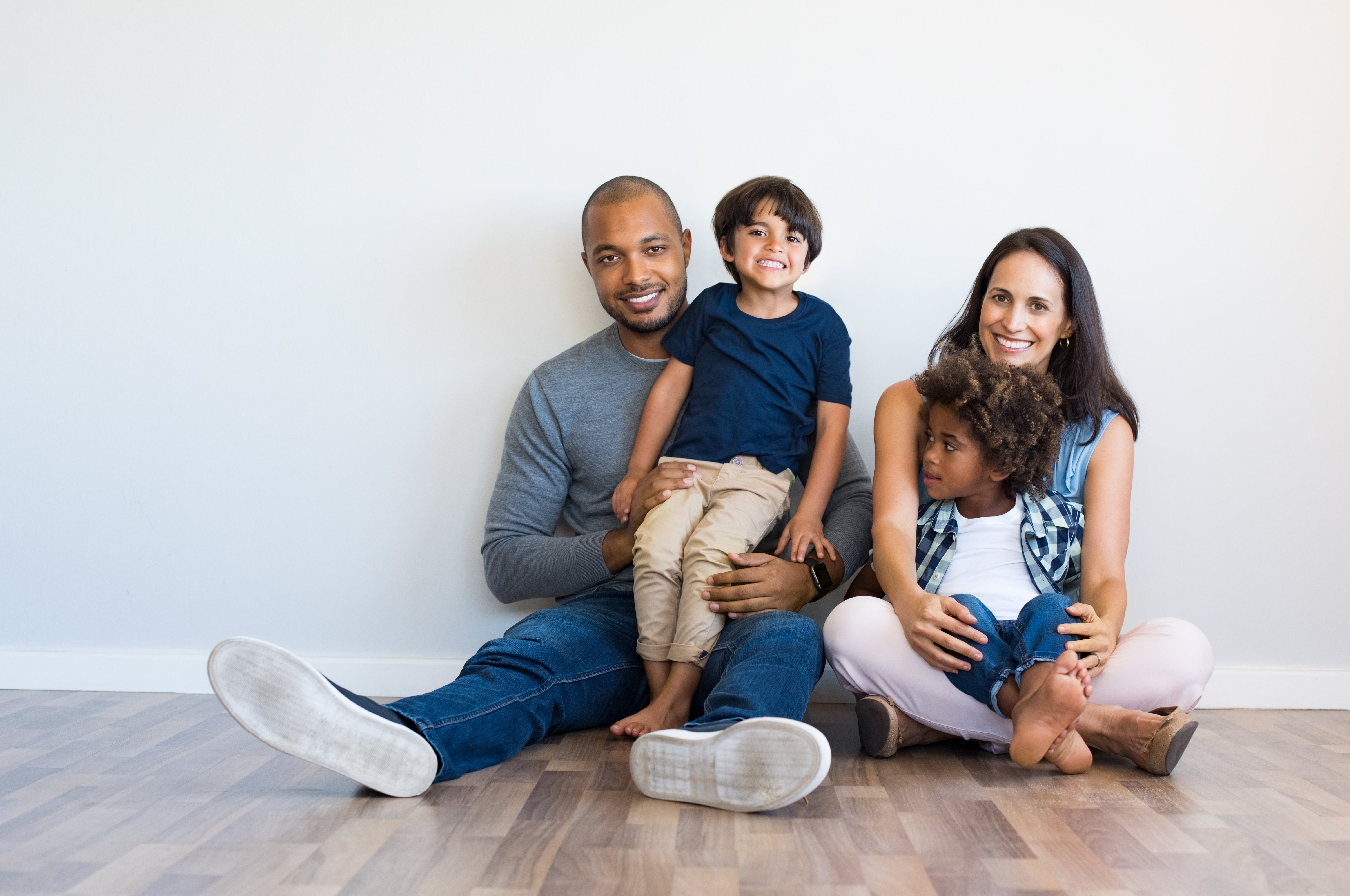 Happy multiethnic family sitting on floor with children-1